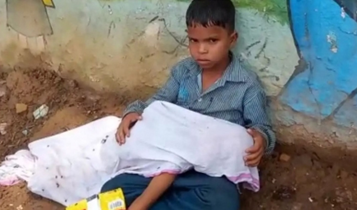 एंबुलेंस की आस में छोटे भाई के शव को गोद में लेकर बैठा आठ वर्षीय लड़का, वीडियो वायरल